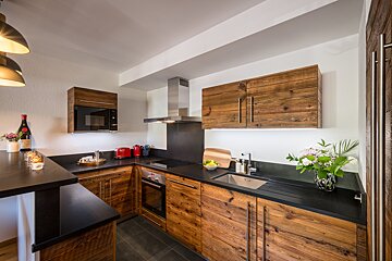A kitchen with wooden cabinets and black counter tops