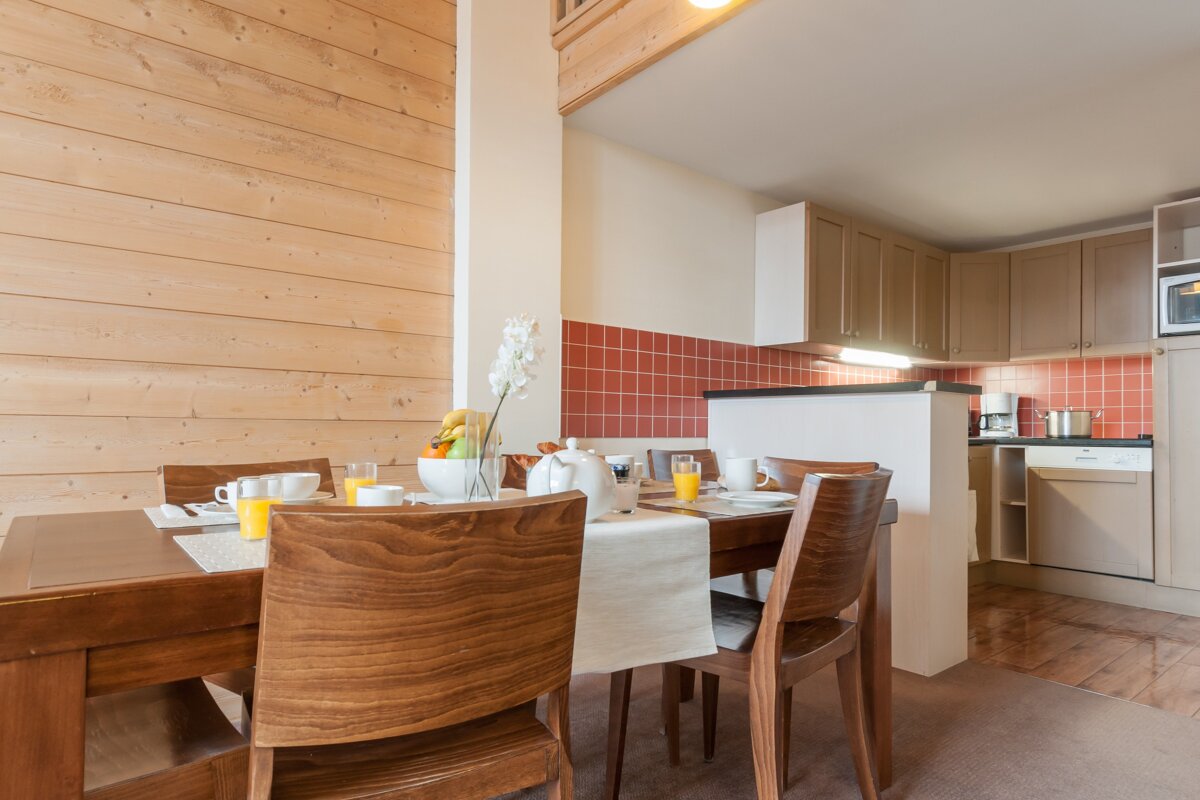 A dining room with a table and chairs and orange juice