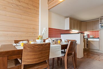 A dining room with a table and chairs and orange juice