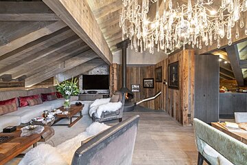 A living room with a chandelier hanging from the ceiling
