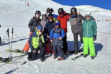 A group of skiers are posing for a picture in the snow
