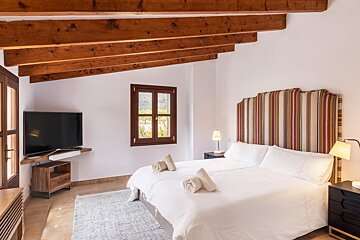 A bedroom with a large bed and a flat screen tv