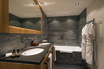 A bathroom with two sinks and a bathtub