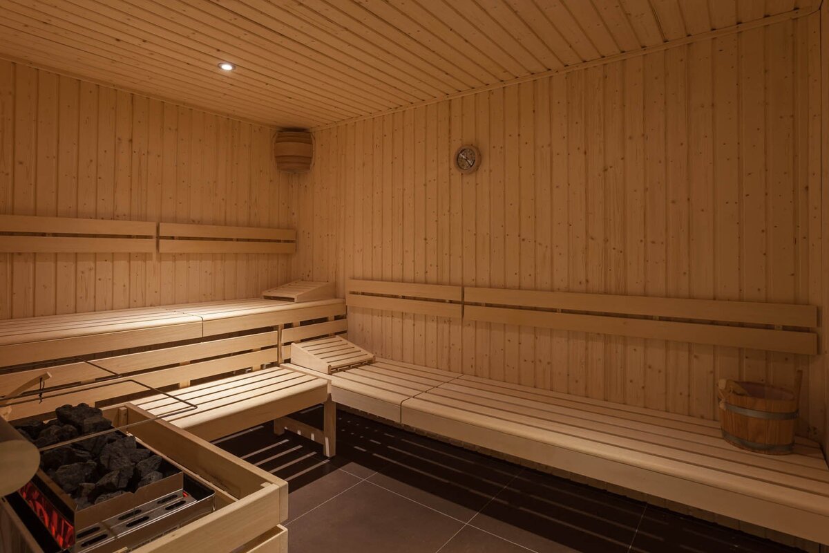 A wooden sauna with a bucket in the corner