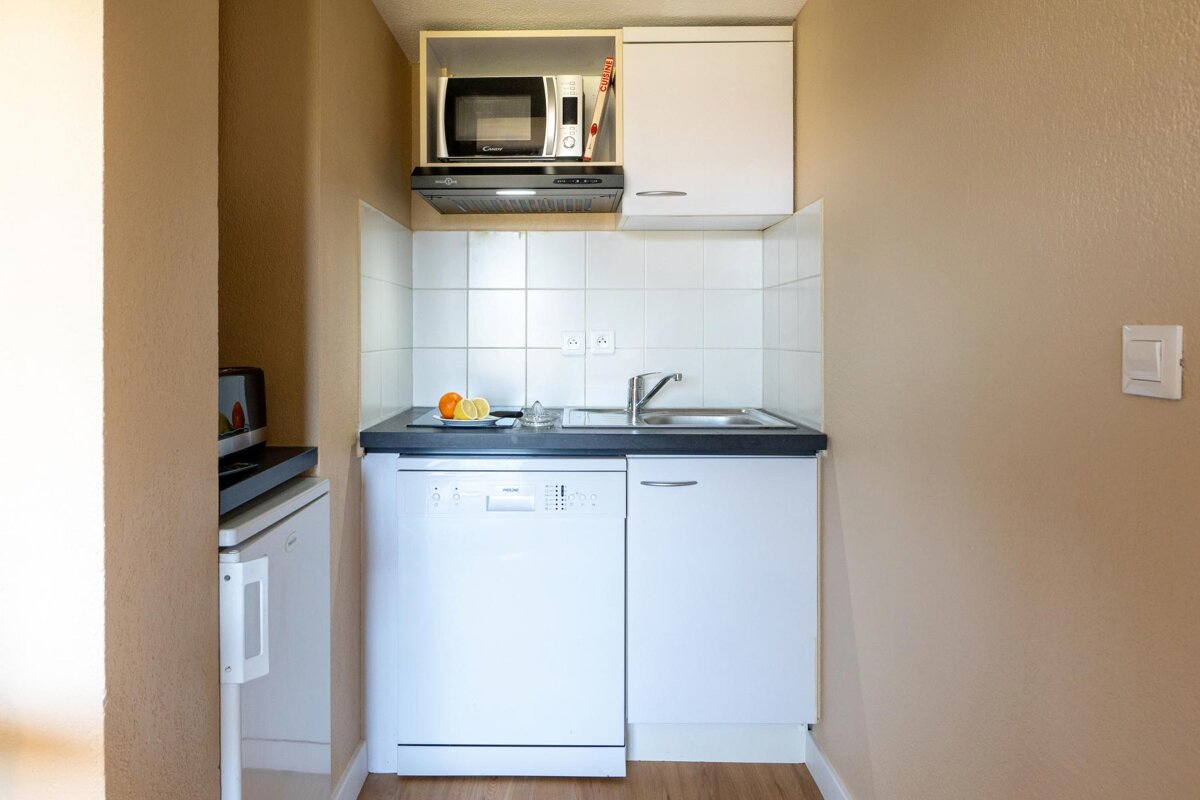 A small kitchen with a dishwasher a sink and a microwave
