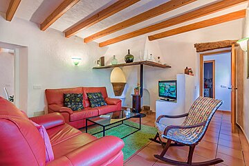 A living room with a red couch and a rocking chair