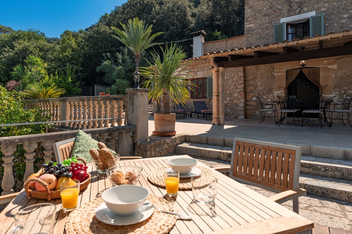 A wooden table with bowls of food and orange juice on it