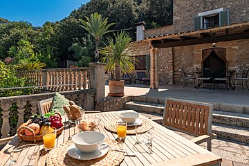 A wooden table with bowls of food and orange juice on it