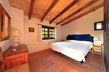 A bedroom with a blue headboard and white sheets