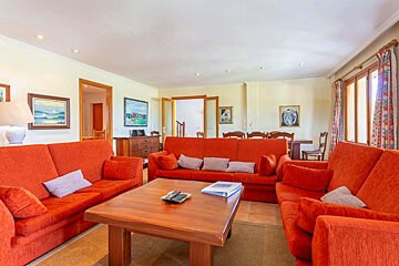 A living room with red couches and a wooden table