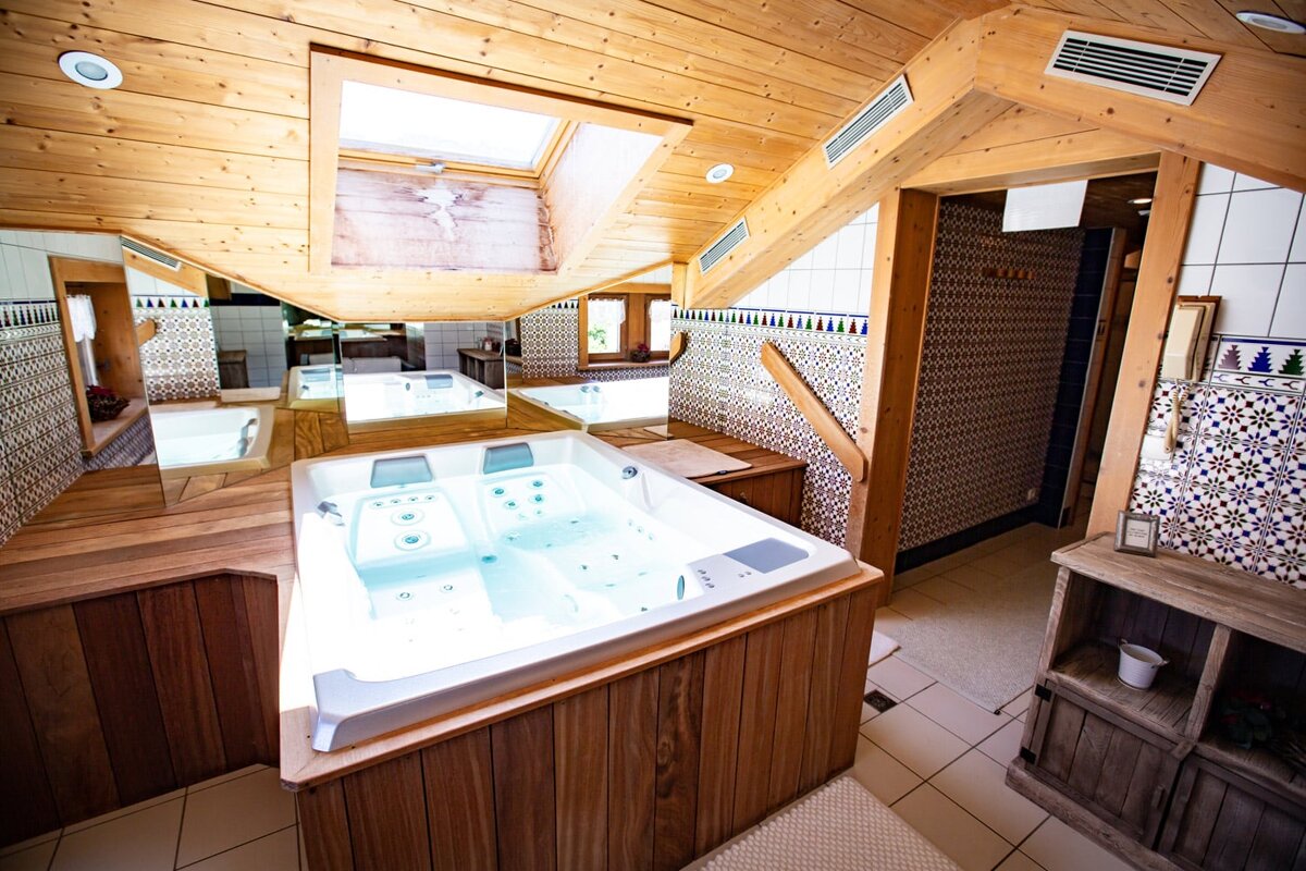A bathtub in a bathroom with a skylight above it