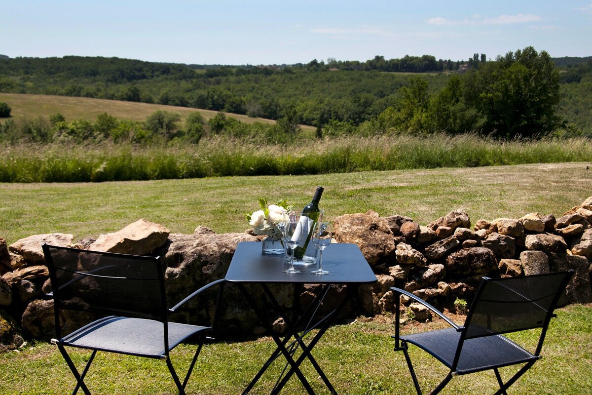 Two chairs and a table with a bottle of wine on it