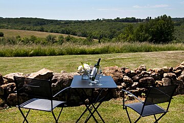 Two chairs and a table with a bottle of wine on it