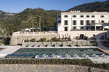 A large white building with a large swimming pool in front of it