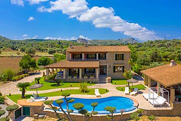 A large house with a large swimming pool in front of it
