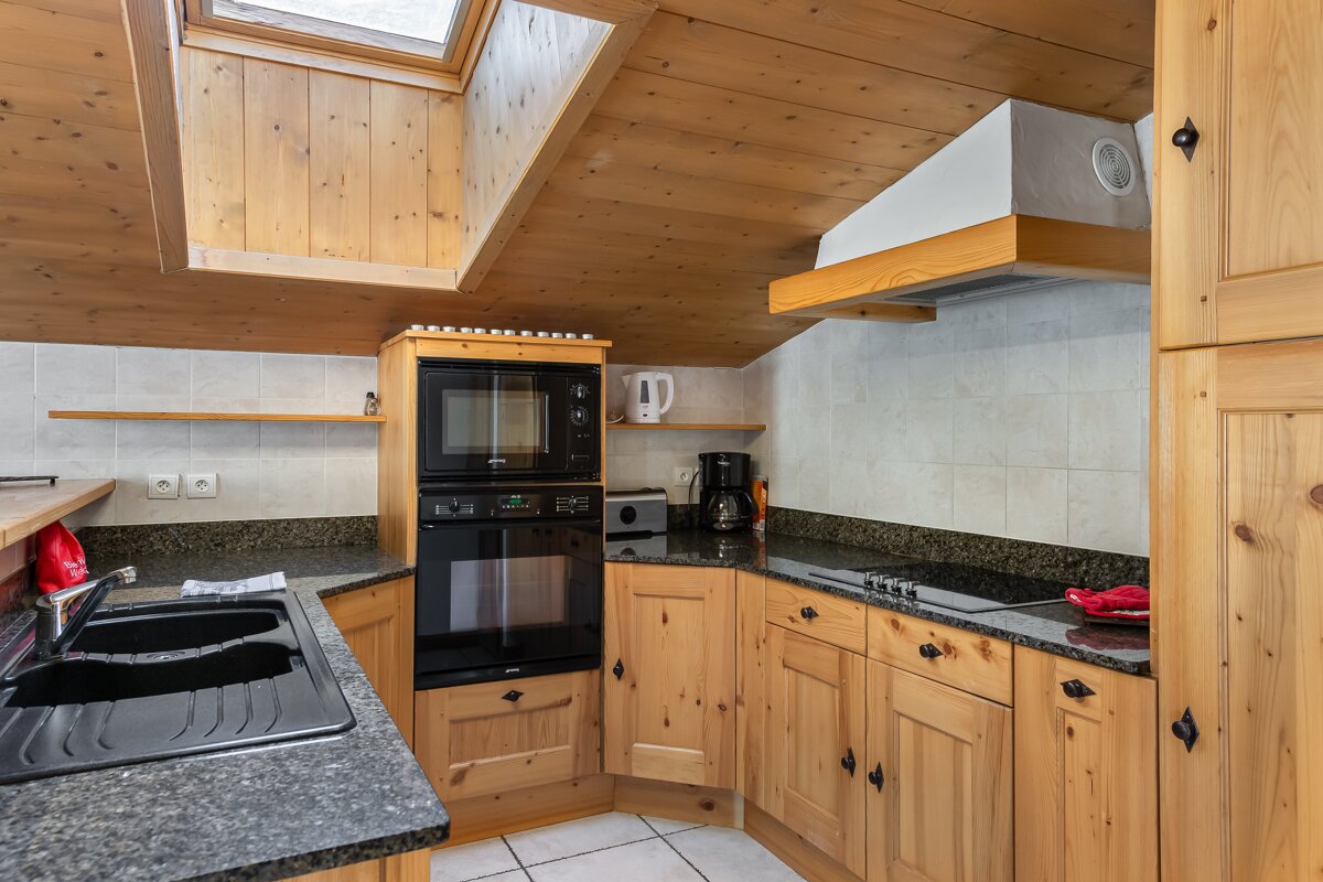 A kitchen with wooden cabinets and granite counter tops