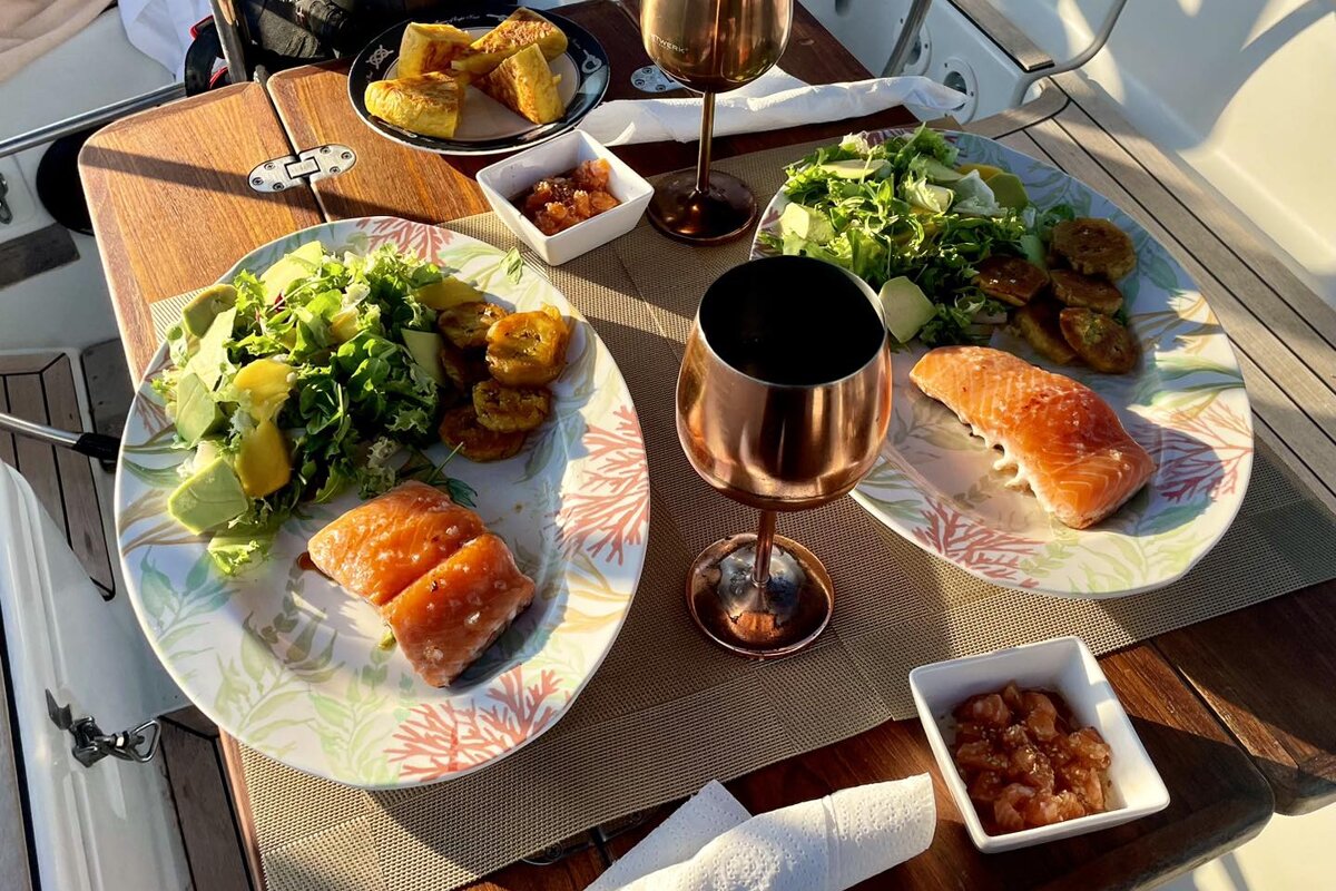 Two plates of food and two glasses of wine on a table