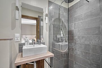 A bathroom with a sink a mirror and a shower