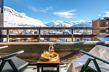 A balcony with a view of a snowy mountain range