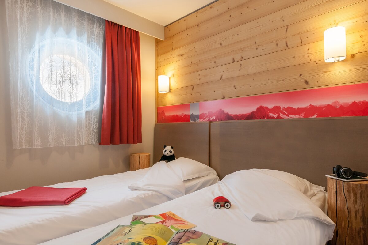 A bedroom with two beds and a book on the bed