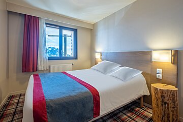 A hotel room with a bed and a window