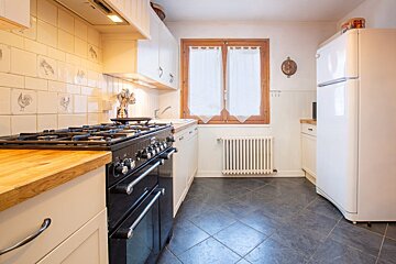 A kitchen with a stove top oven and a white refrigerator