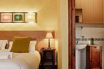 A bedroom with a bed and a lamp next to a sink