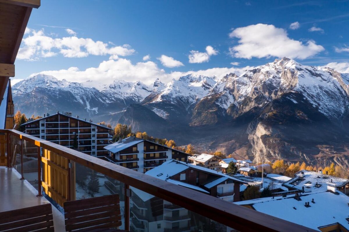 A balcony with a view of a snowy mountain range