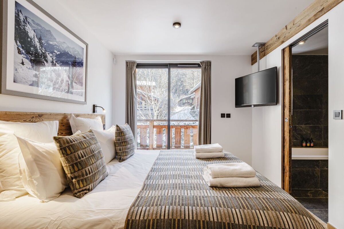 A bedroom with a large bed and a flat screen tv