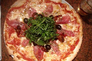 a pizza with ham and olives