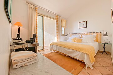 A bedroom with a yellow blanket on the bed