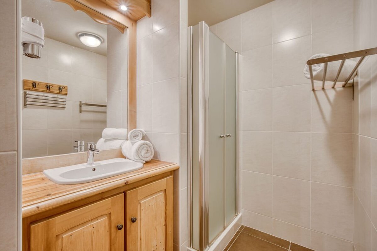 A bathroom with a sink and a shower stall