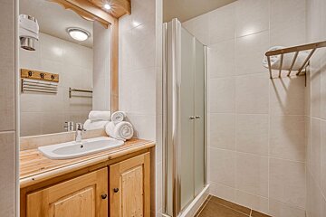 A bathroom with a sink and a shower stall