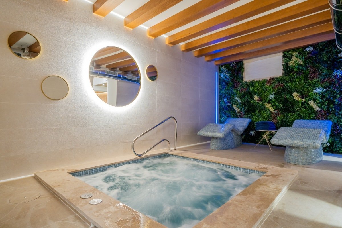 A jacuzzi in a room with a green wall
