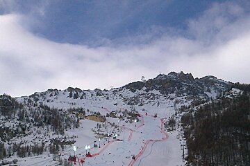 A snowy mountain with a ski slope in the foreground