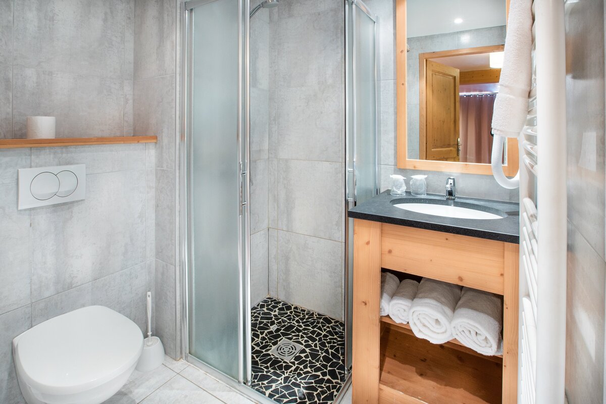 A bathroom with a toilet a sink and a mirror