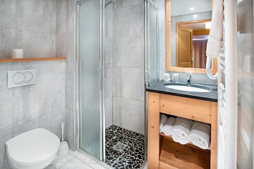 A bathroom with a toilet a sink and a mirror