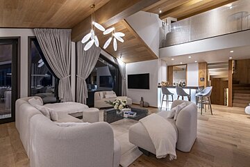 A living room with white furniture and a flat screen tv