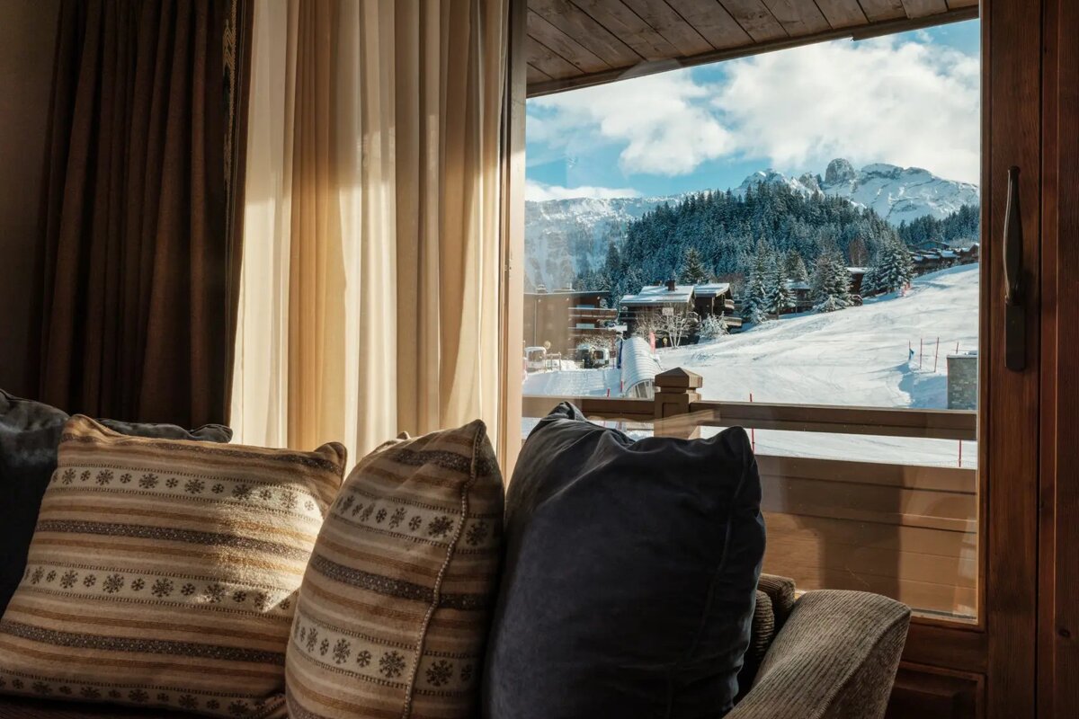 A pillow with snowflakes on it sits in front of a window
