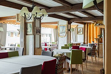 A restaurant with tables and chairs and a chandelier