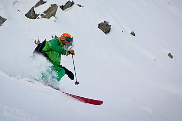 a skier in green outfit