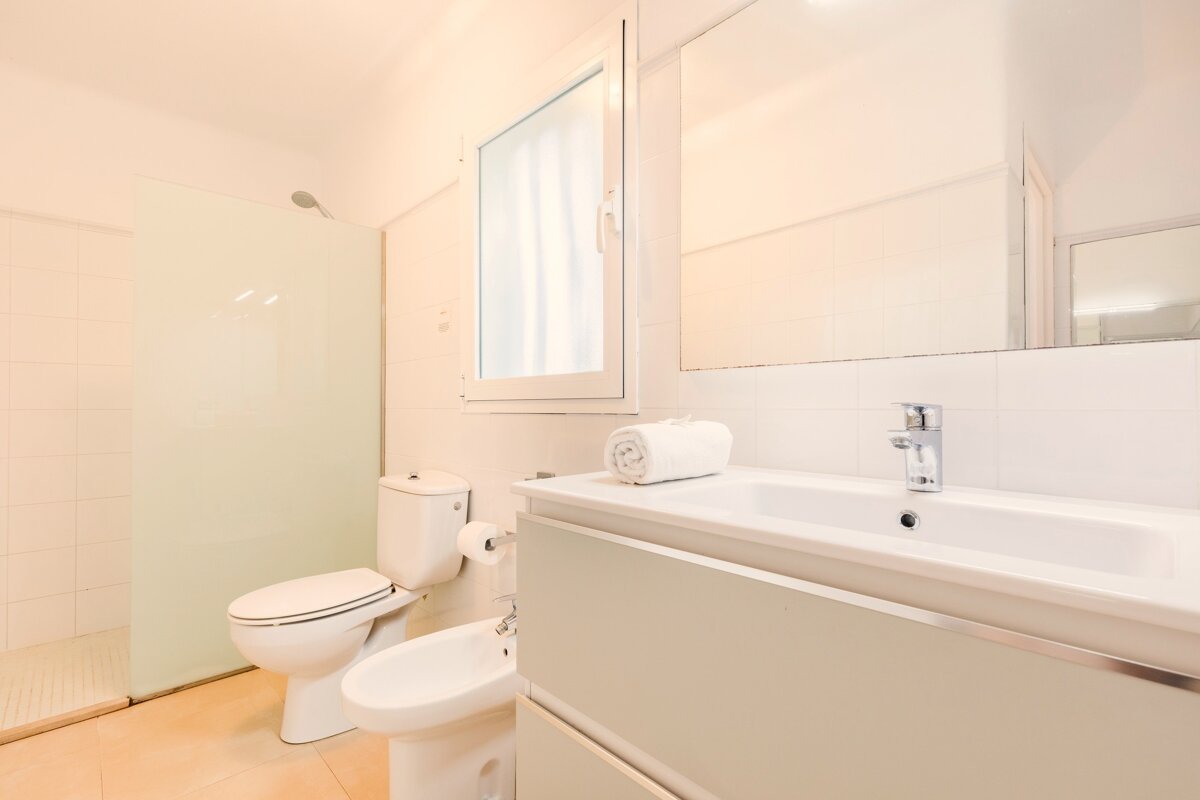 A bathroom with a toilet a sink and a mirror