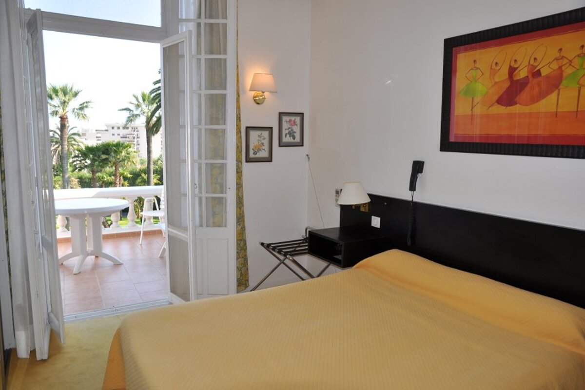 A hotel room with a bed and a balcony