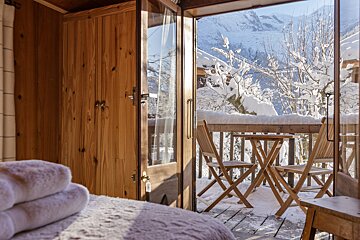 A balcony with a table and chairs in the snow