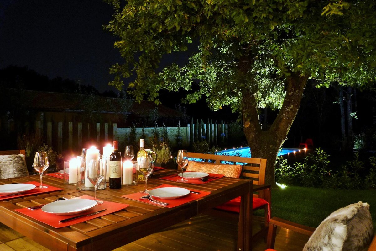 A bottle of wine sits on a table next to candles