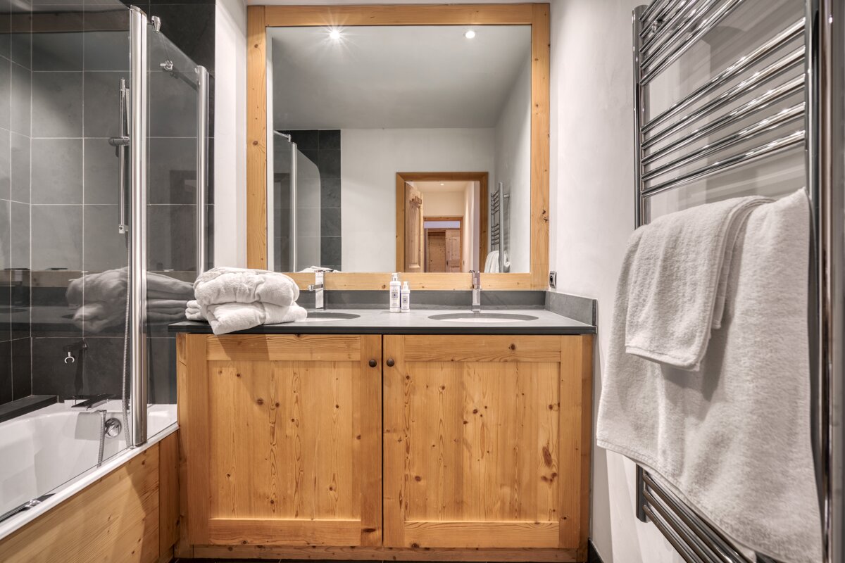 A bathroom with two sinks and a large mirror