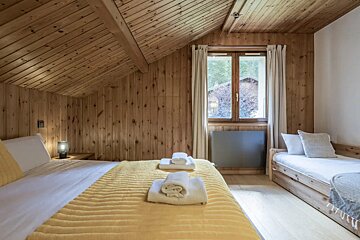 A bedroom with two beds and a window