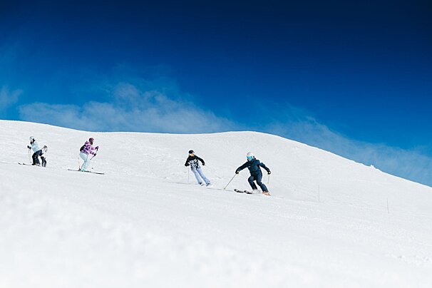 A group of people skiing down a snowy hill