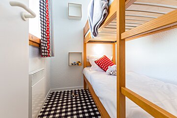 A bunk bed with a teddy bear on it