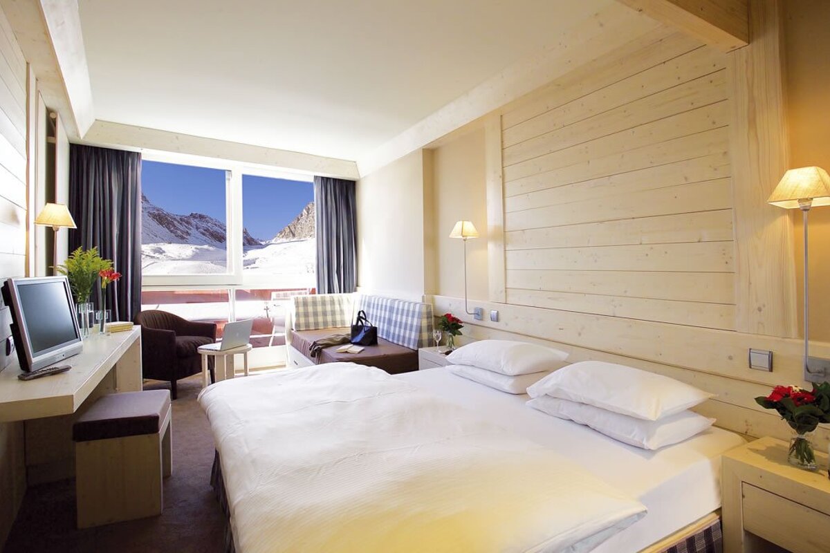 A hotel room with a bed and a television